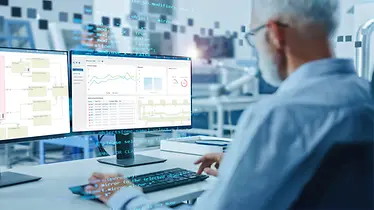 Man analyseert logistieke software WAMAS via een computer